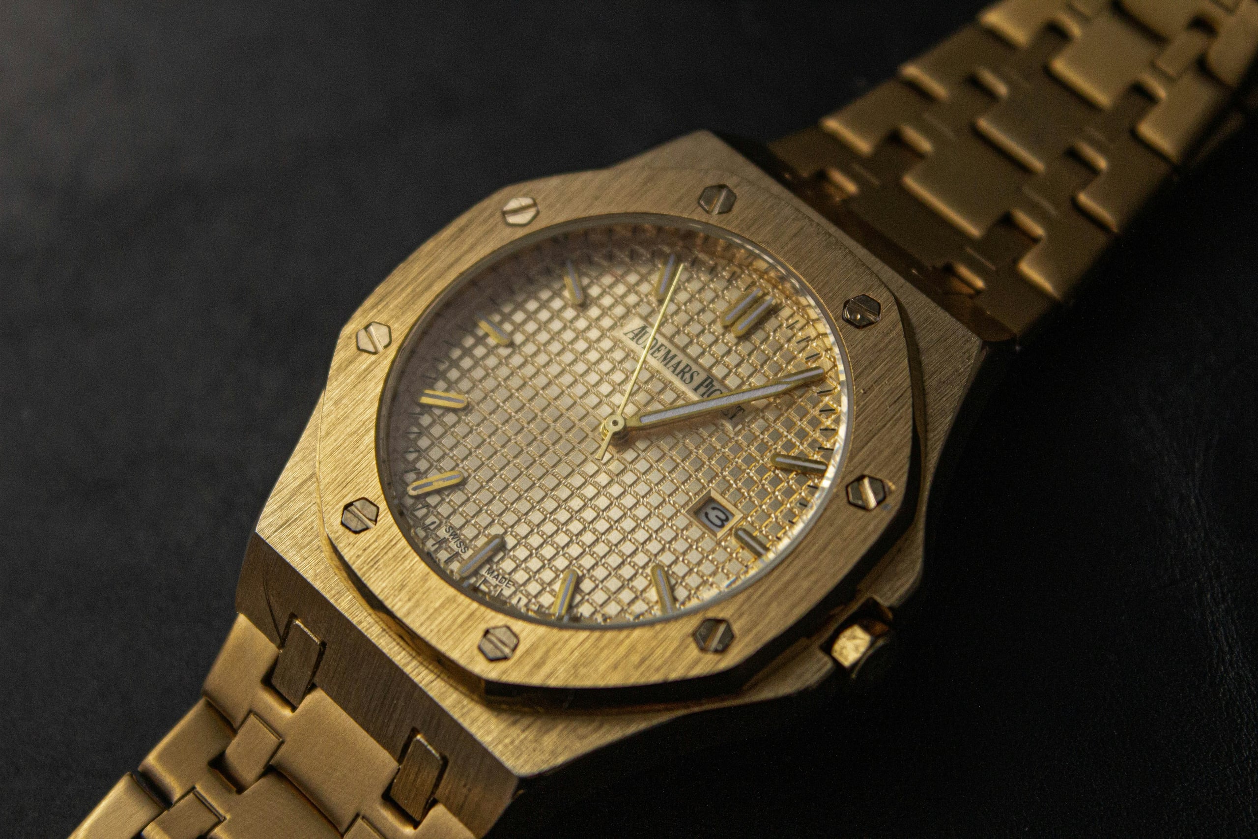 Audemars Piguet Royal Oak in yellow gold with Grande Tapisserie dial on a dark surface